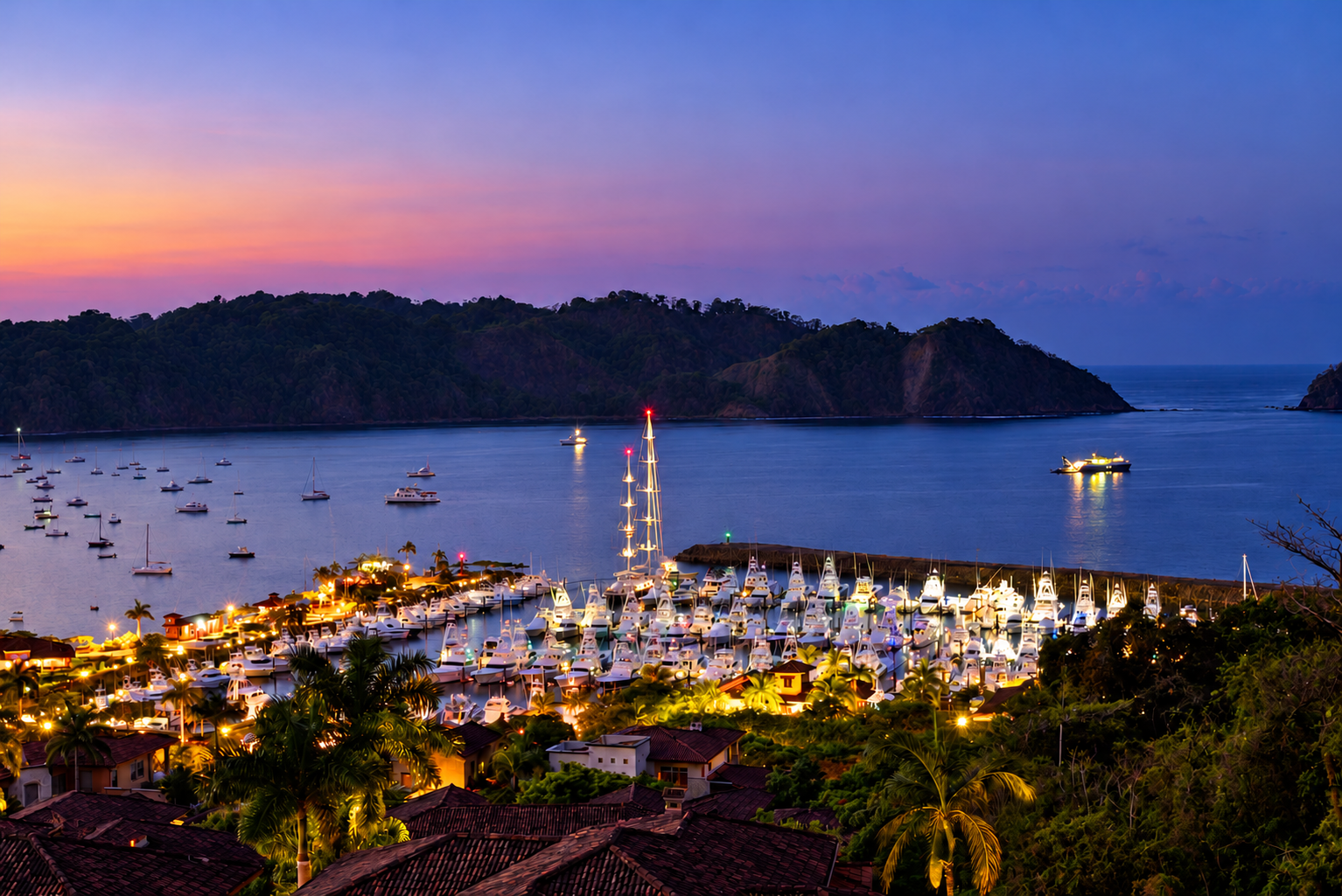 Illuminated yachts and palm trees at Los Sueños Marina overlooking Herradura Bay at dusk