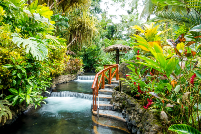 Thermal cascades and a footbridge surrounded by lush gardens at Tabacón, Costa Rica