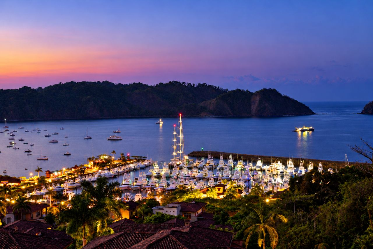 Illuminated yachts and palm trees at Los Sueños Marina overlooking Herradura Bay at dusk